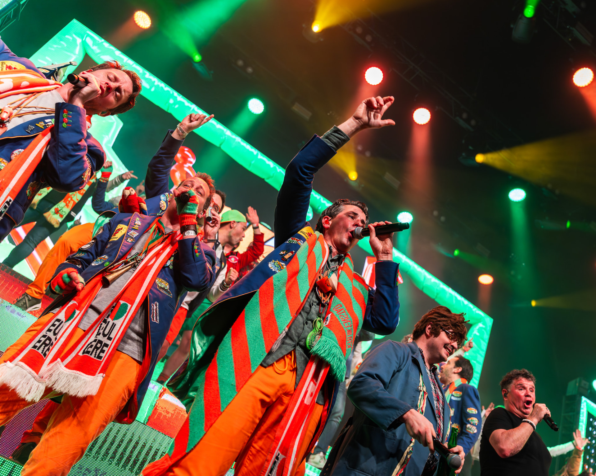 Veul Gere zingt vol energie in groen en oranje showlicht